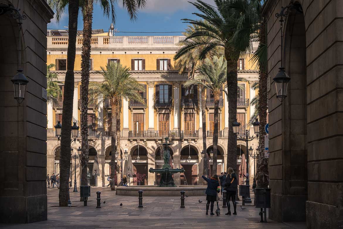 Placa Reial with a fountain surrounded by coconut trees.