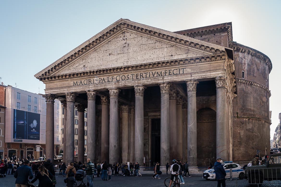 This is a close up of the Pantheon, one of the best places to visit in Rome. There are many people outside.