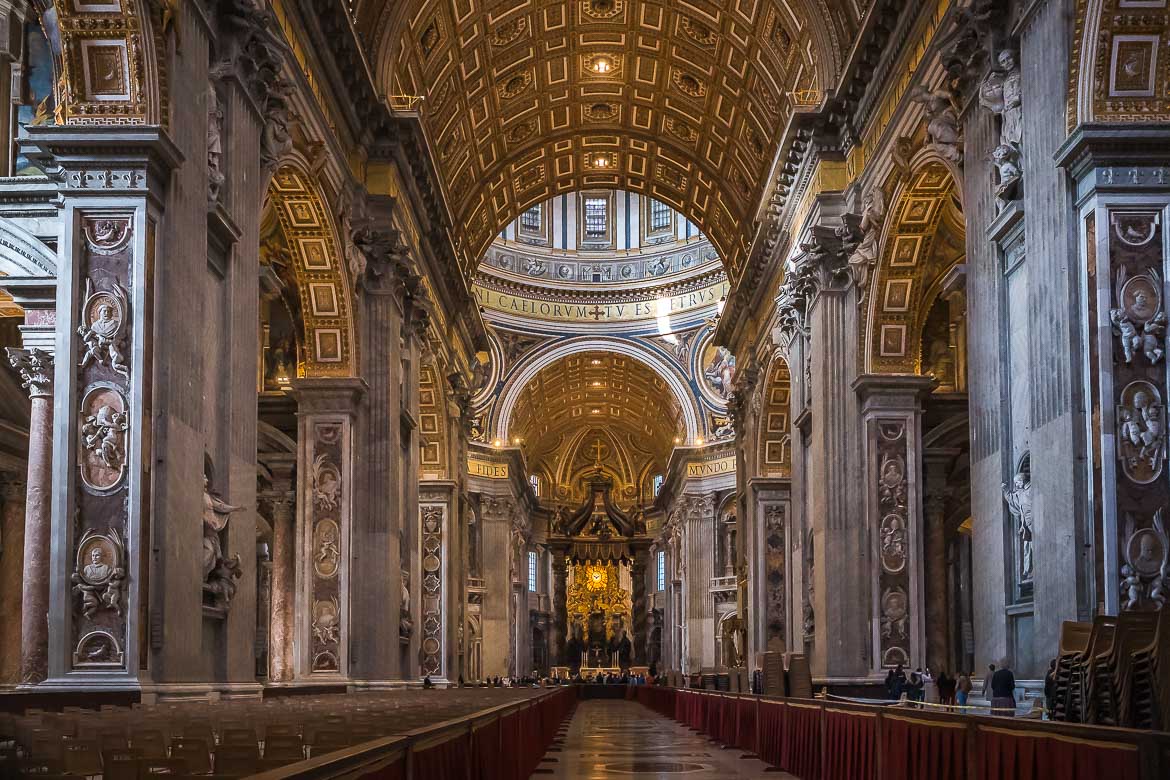This image shows the interior of St. Peter's Basilica with its lush decoration and gold details. In the background, Bernini's Baldachin is visible.