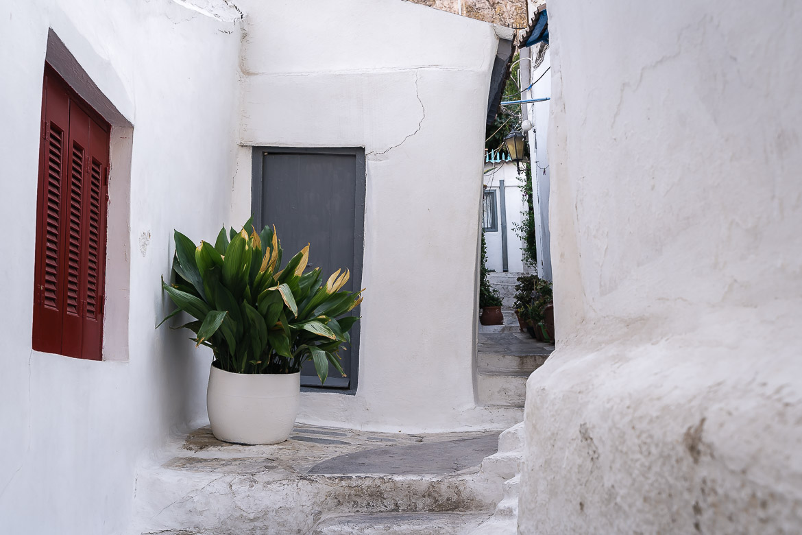 This image shows a a quaint white street in Anafiotika neighbourhood in Plaka, an essential stop on your Athens in 3 days itinerary.