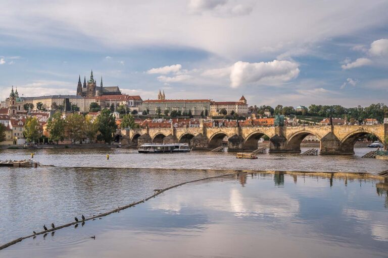 Panoramic view of Charles Bridge and Prague Castle from the Old Town's riverbank.