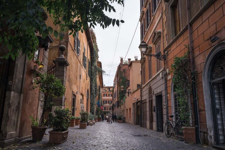 This image shows a picturesque street in Rome and it's the feature image of our article Best Areas To Stay in Rome.