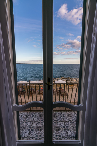 This photo shows the view to the sea from inside the closed french windows in our room at Punta Cutieri.