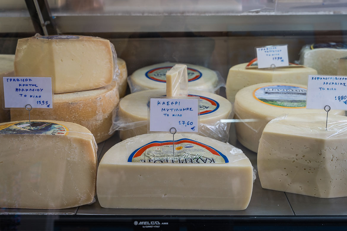 Different kinds of local Greek cheese displayed in a fridge.
