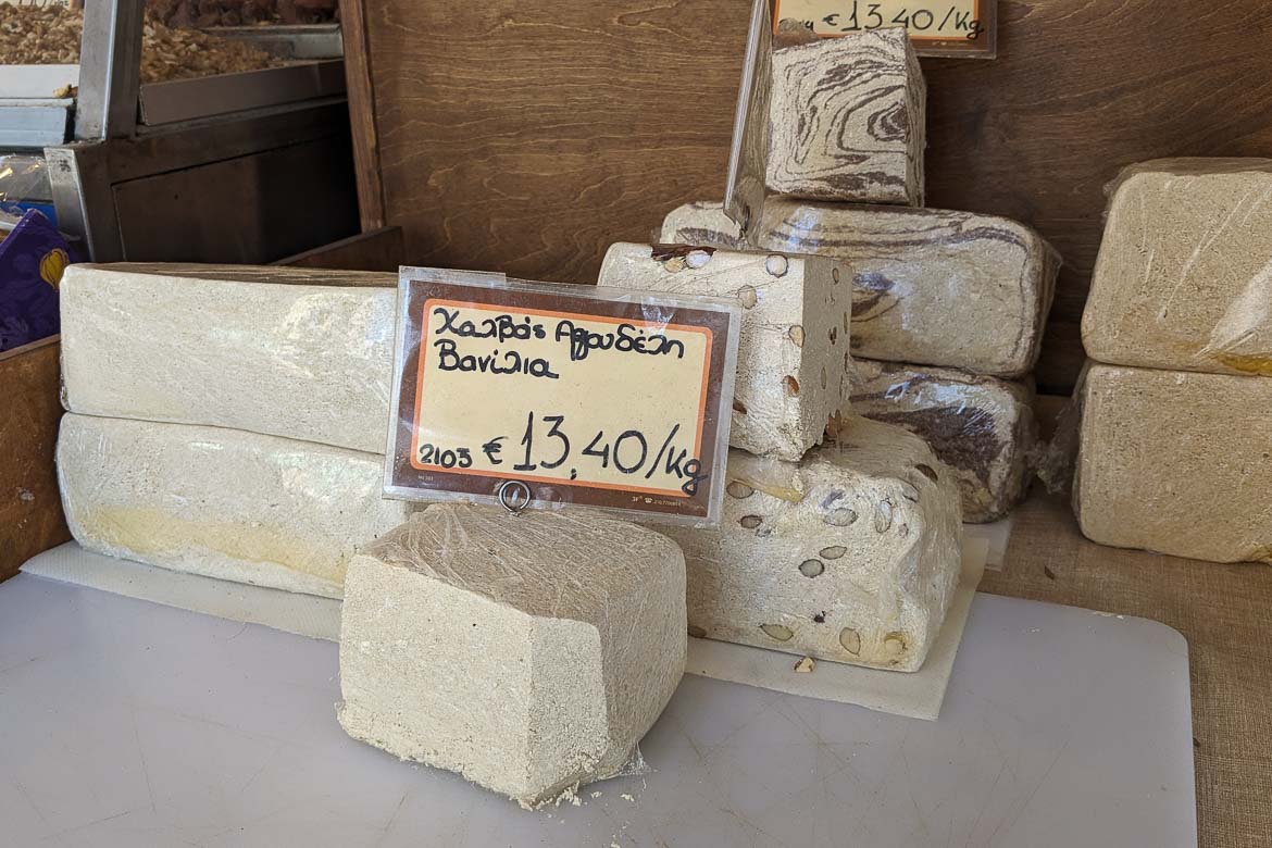 Big pieces of different kinds of halva to be sold in bulk at a grocery store.
