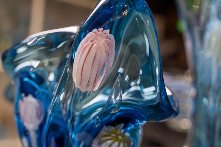 Pink flower built in a blue glass vase.