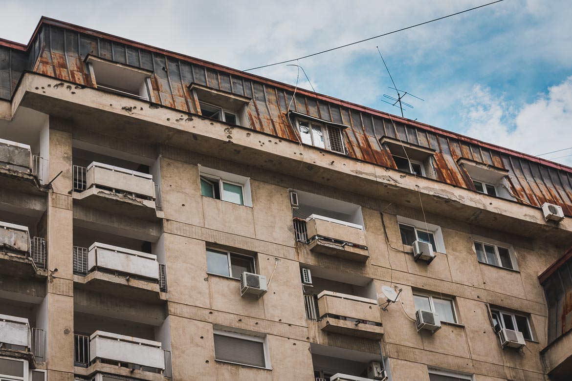 This photo shows the great number of bullet holes on buildings near Revolution Square. Bucharest walking tour of Communism, Romania.