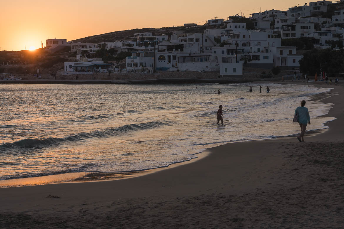 People on the sandy beach of Donoussa at sunset.