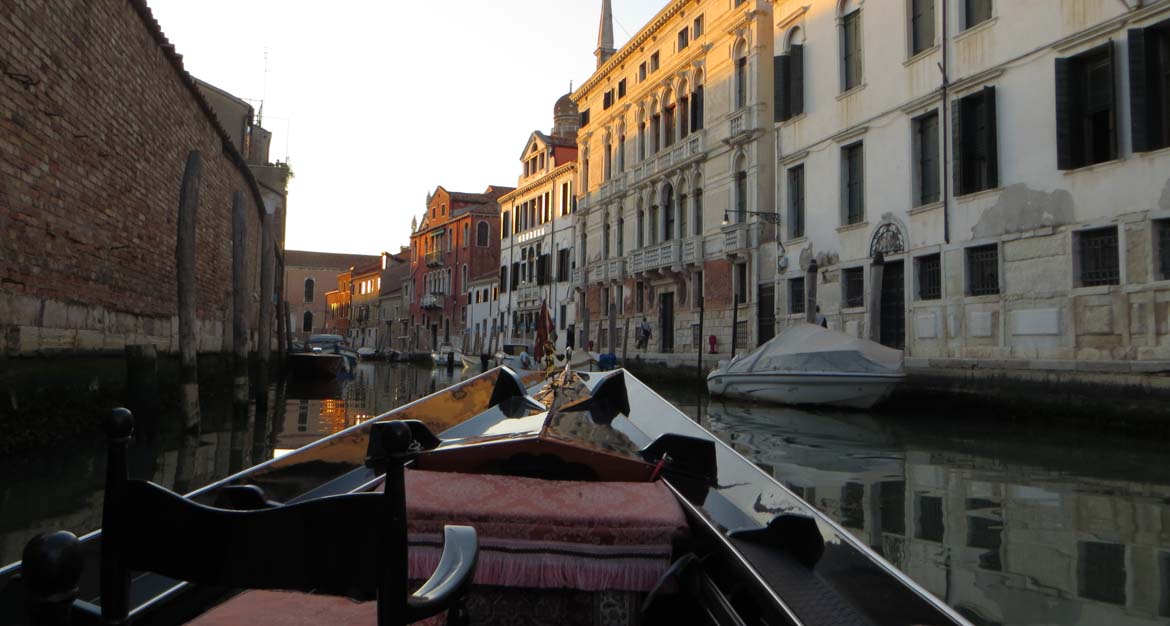 This picture is taken from a private gondola ride and it shows a peaceful canal with beautiful buildings on both of its banks. Top things to do in Venice Italy.