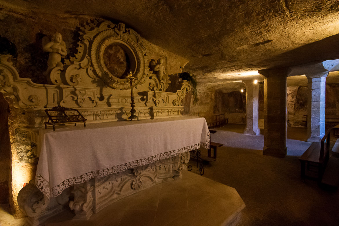 This photo was shot inside the Crypt of Santa Cristina. There is an altar with a precious Virgin Mary icon above it. In the background, the frescoes on the walls are barely visible. 