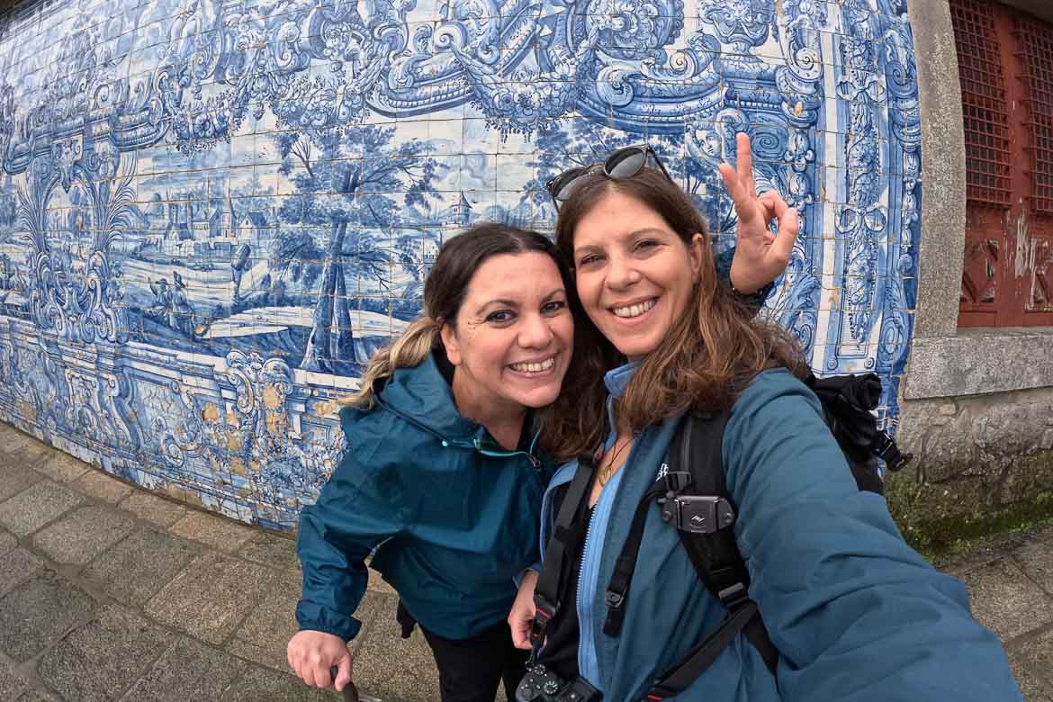 This is a selfie of Katerina and Maria in front of an azulejo-covered wall in Porto.