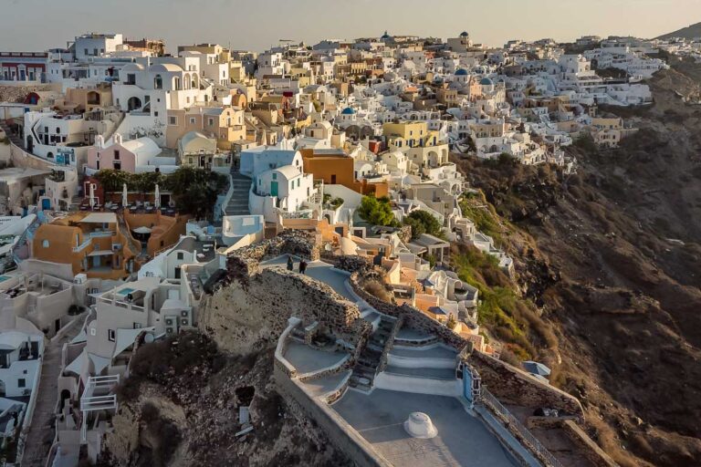 This is a drone shot of Oia, the whitewashed village perched on the rim of the caldera in Santorini.