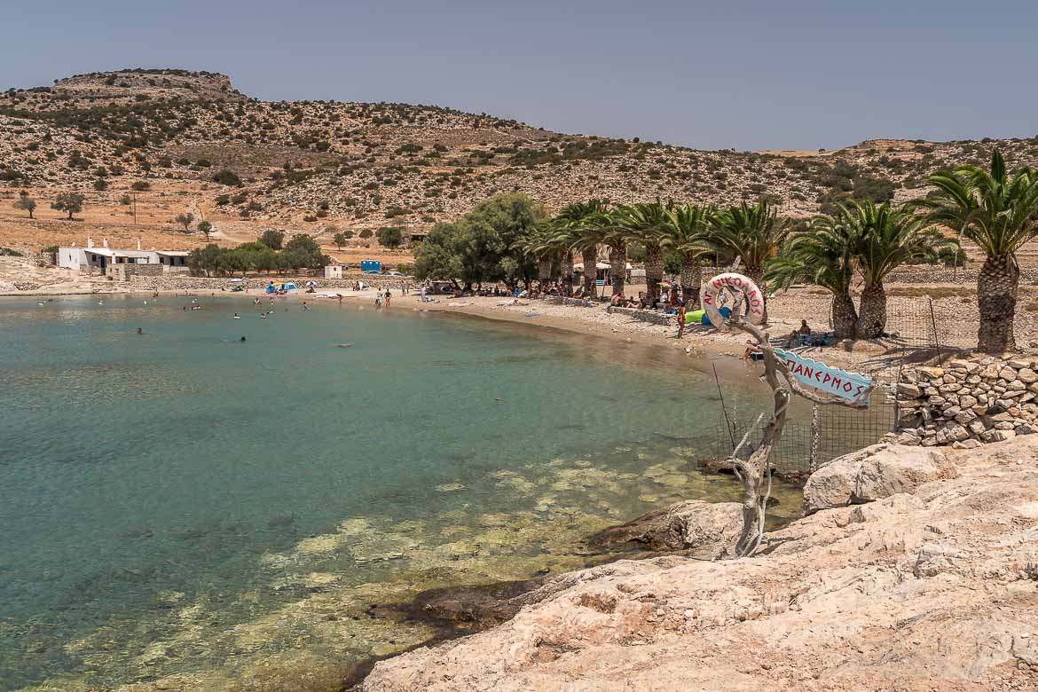 Panoramic view of Panormos Beach lined with palm trees.