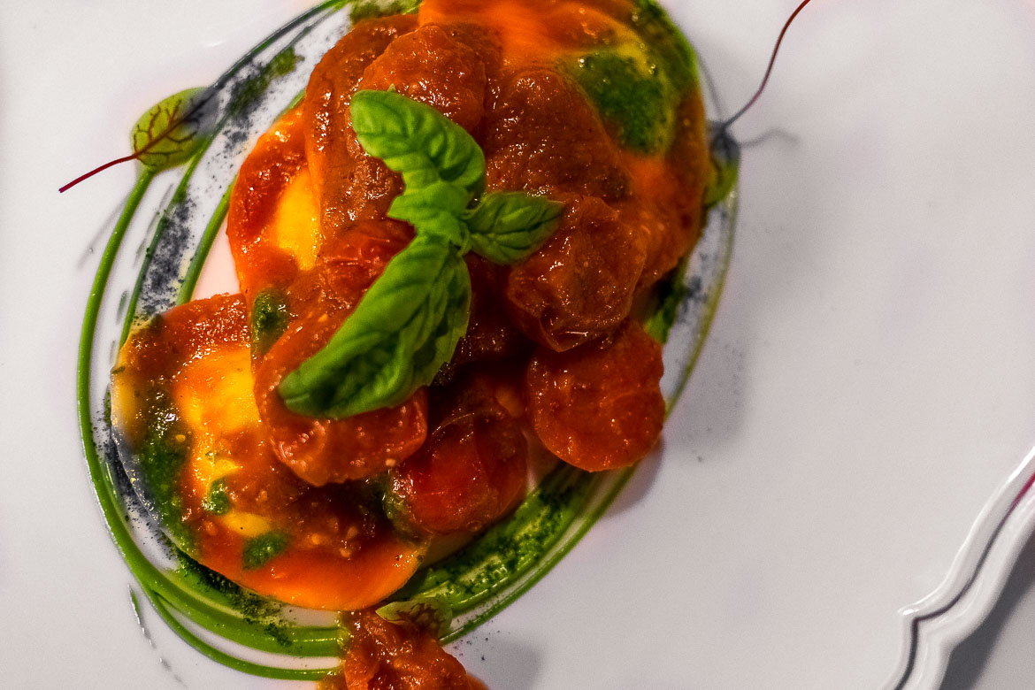 This is a close up of a mouthwatering dish of Fresh pasta with tomato and basil sauce.