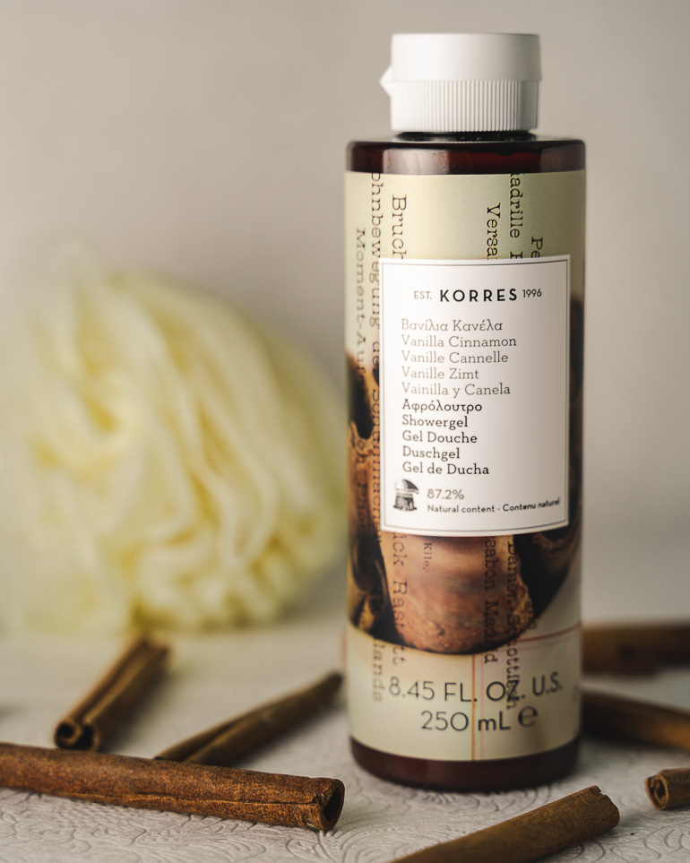 This image shows a Korres shower gel with some cinnamon sticks next to it.