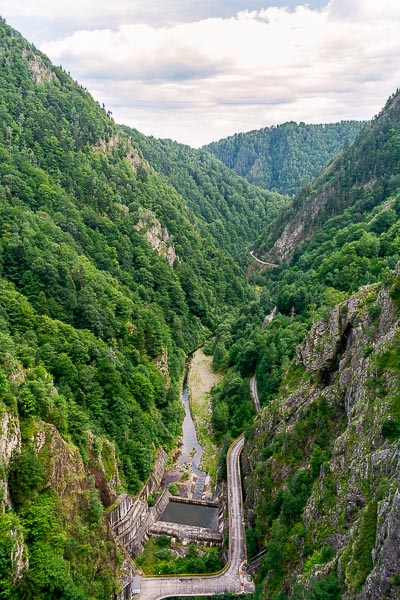 This photo was taken from the Vidraru Dam. It is a view of the mountains surrounding the dam. Everything is green.