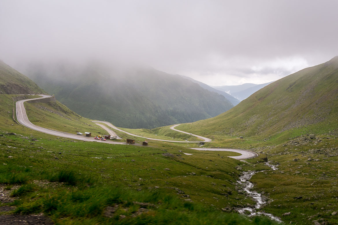This is a photo of the famous Transfagarasan hairpins. The scenery is stunning. Everything is green and only the road interrupts the natural surroundings.