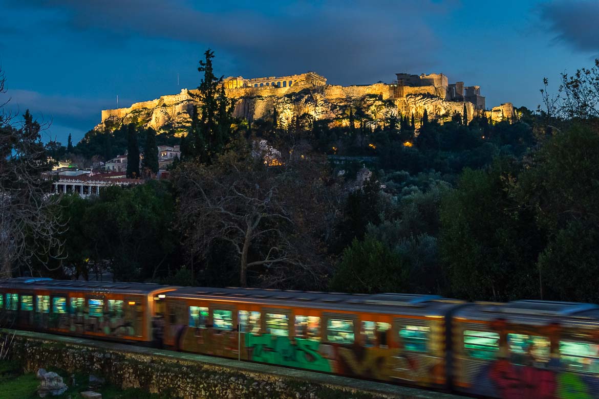 Metro line 1 on its way to Thissio station with the illuminated Acropolis in the background.