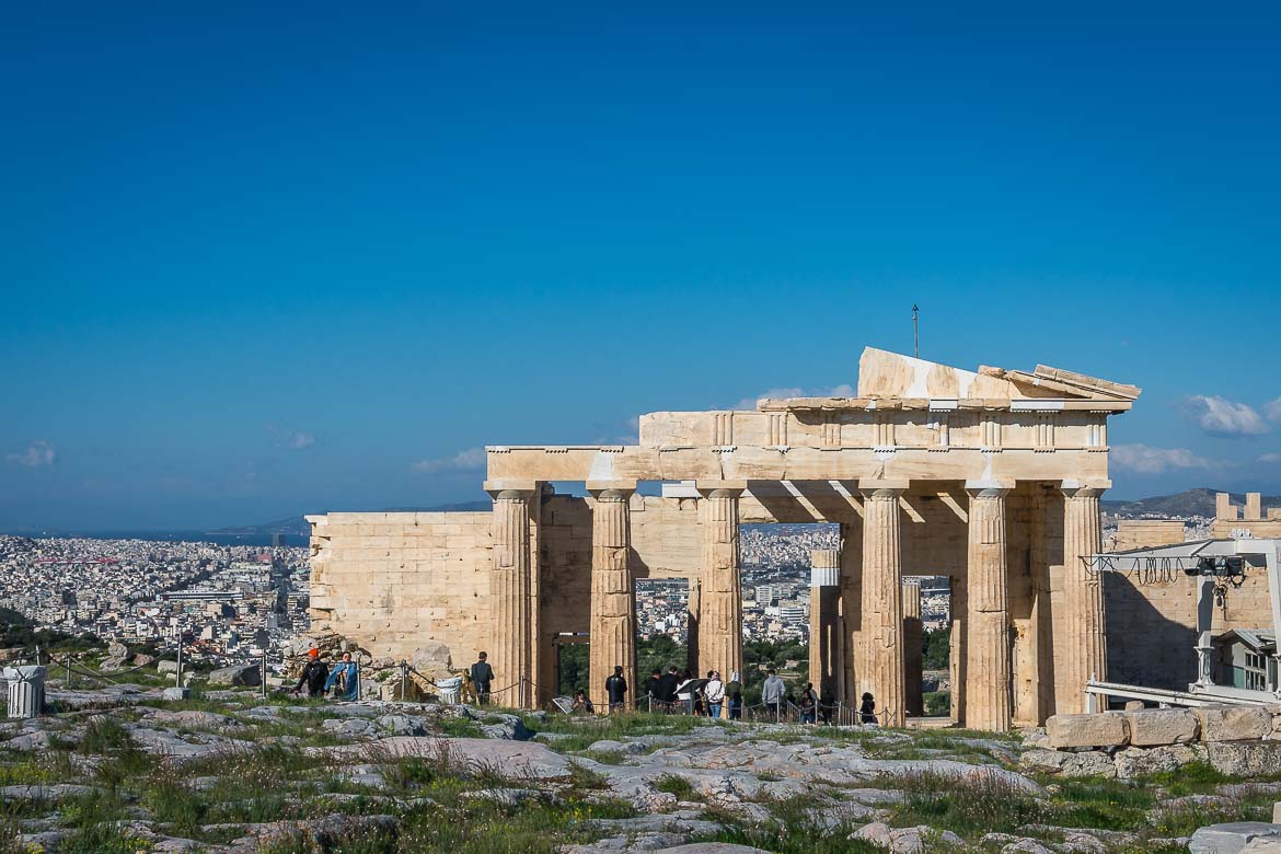 The Parthenon under a clear blue morning sky with only a few people around.