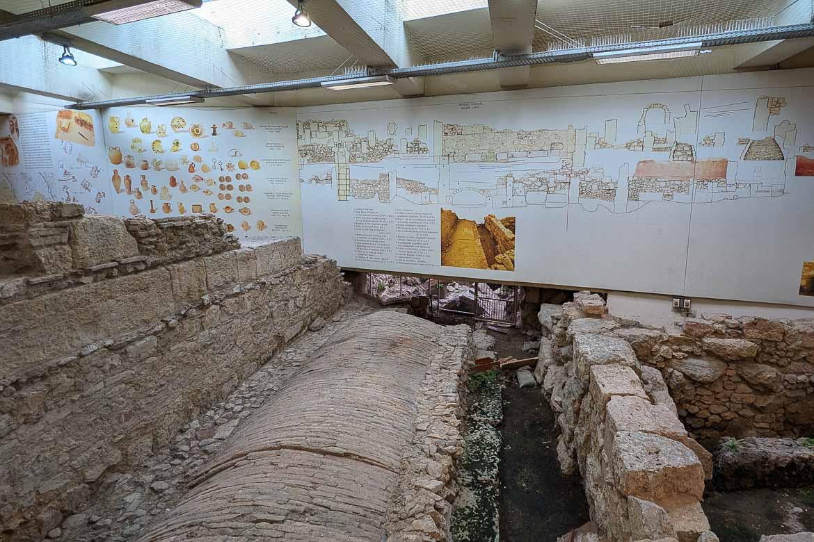 Underground ancient ruins at Monastiraki Metro station. There is a big sign over the ruins with drawings and text for more details. One of the best travel tips for Athens is to look for ancient ruins where you least expect them. 