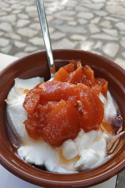 A bowl with Greek yoghurt and quince spoon sweet on top.