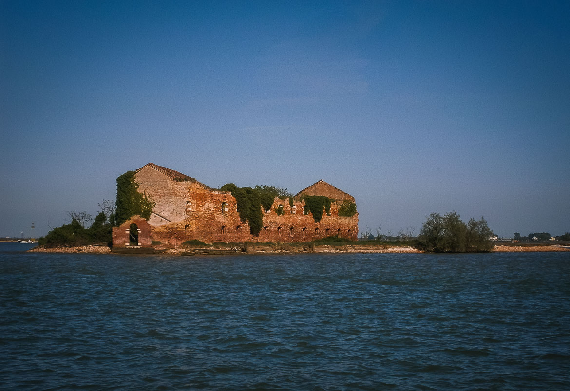 This photo shows a deserted island with a ruined building at the Venetian Lagoon, Veneto Italy. Venice islands, the perfect Venice day trip.