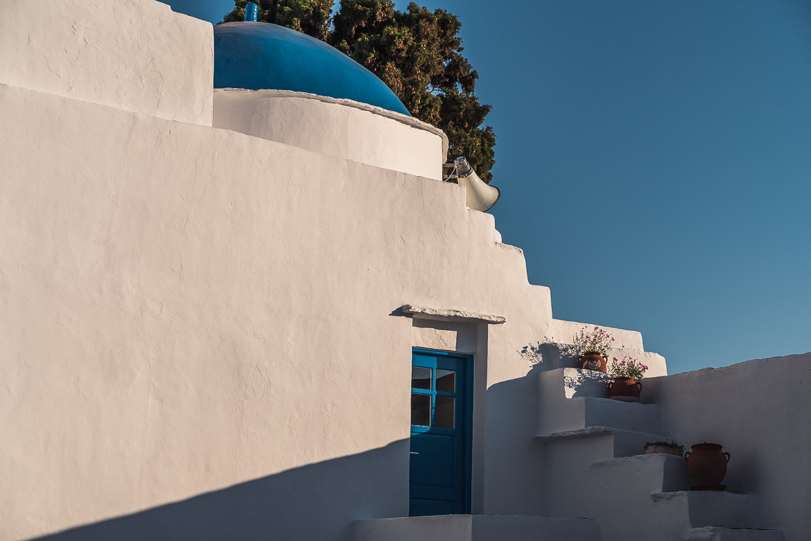 This is a close up of a whitewashed blue-domed church. 