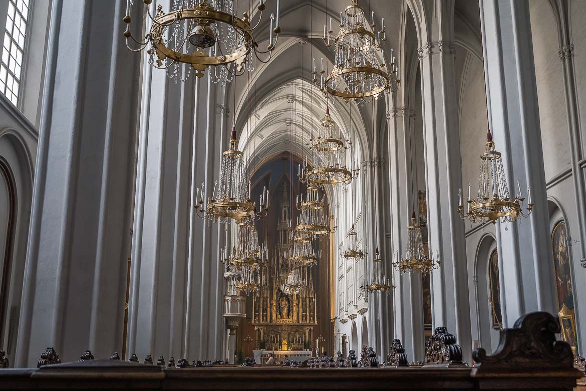 The Augustinian Church's interior with several chandeliers hanging from the vaulted ceiling.