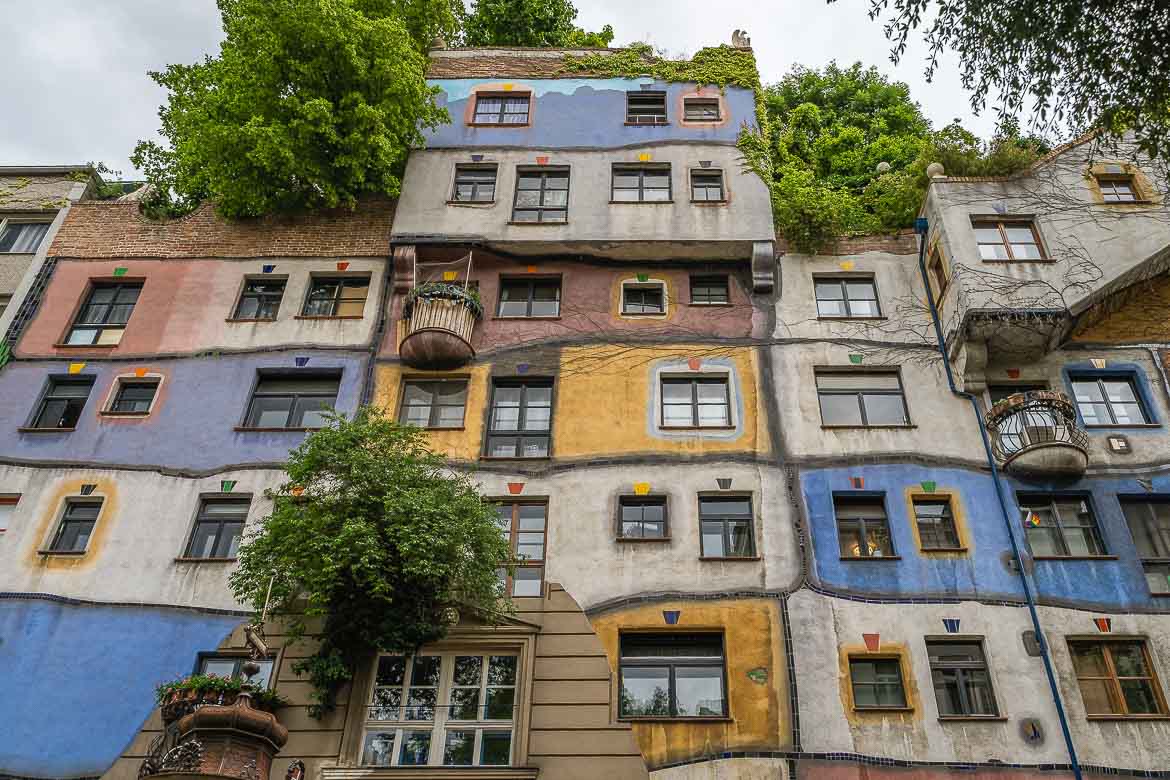 The colourful facade of Hundertwasser House. The facade is divided into blue, yellow, red and green boxes with wavy lines.