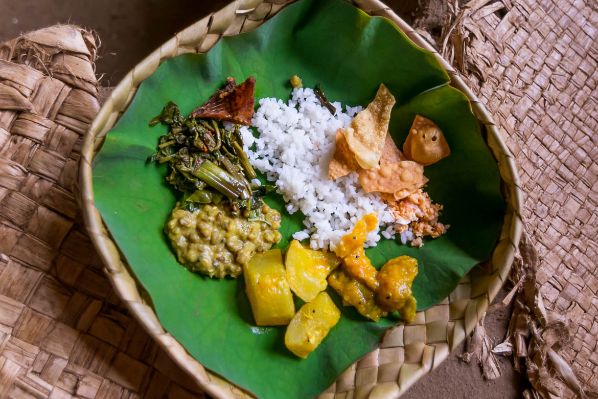 This photo shows food served inside a plate made of cane or coconut leaves. 