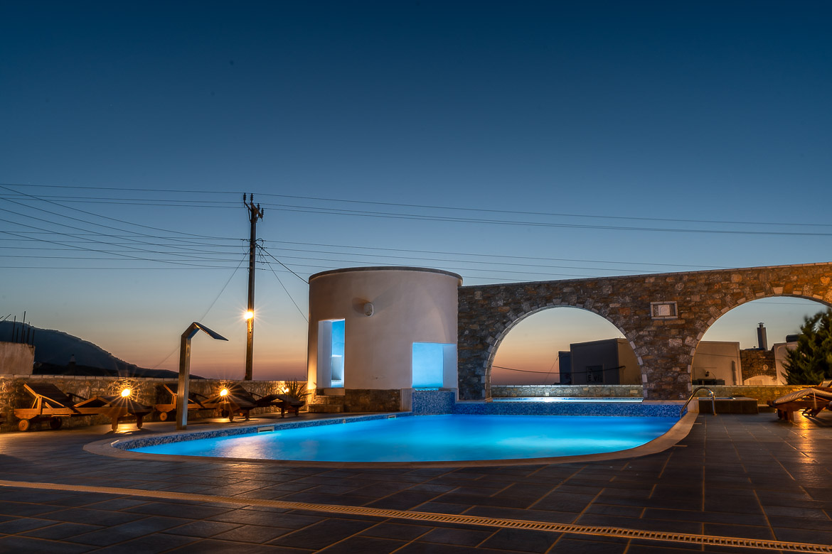 This image shows the swimming pool at Vigla Hotel AMorgos all lit up right after sunset.