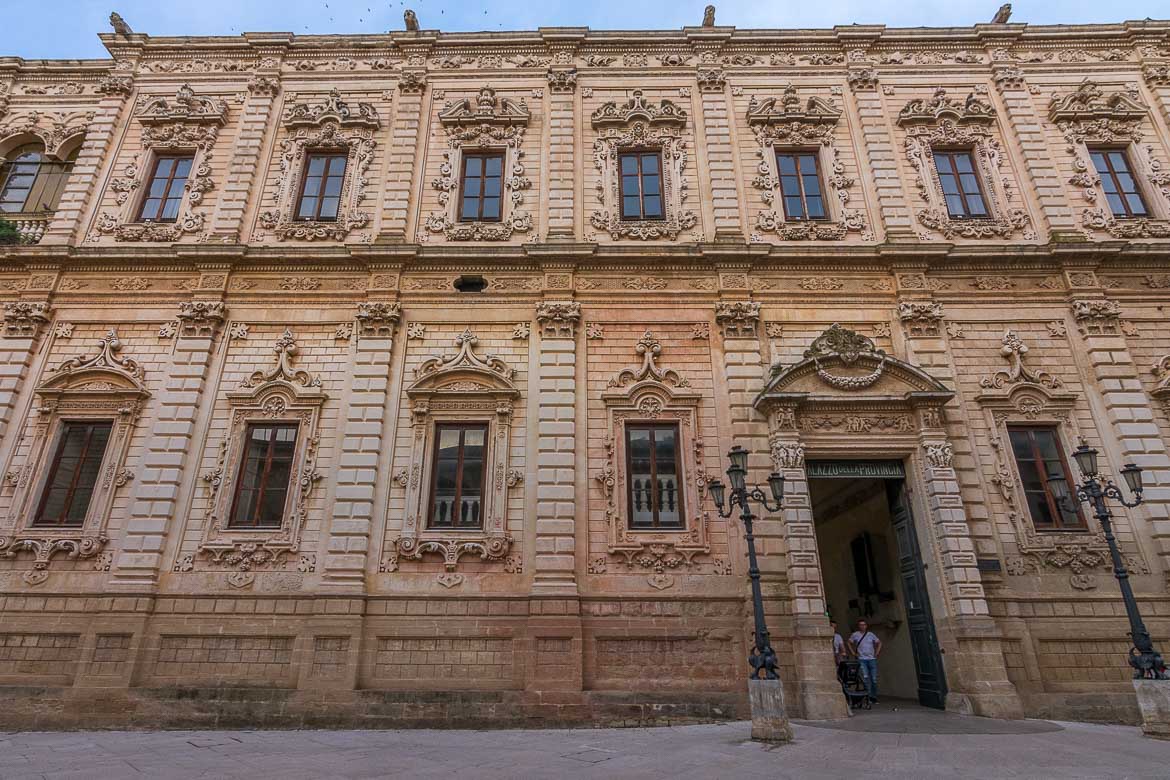 This photo shows a facade of a historical building in Lecce. There are elaborate details and it is a typical example of the barocco leccese architectural style.
