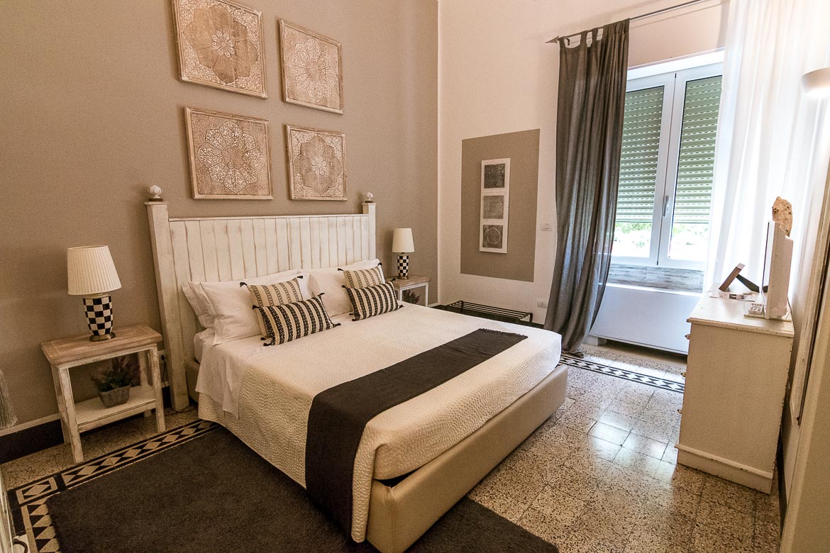 This is a photo of one of the rooms at Palazzo Bignami. The room is beautifully decorated in white and grey colours. 