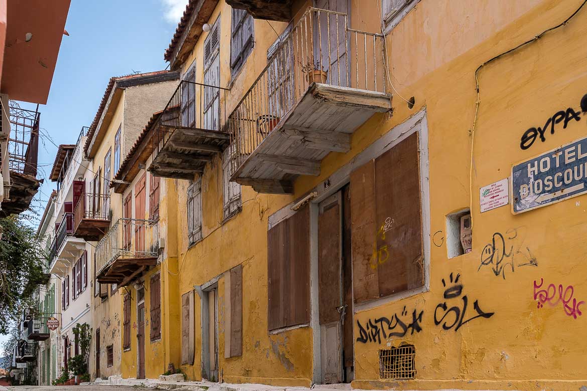 This image shows an alley in the Psaromachalas neighbourhood. The buildings are old and not renovated. If you're wondering what to do in Nafplio, walking around the narrow alleys is a must!