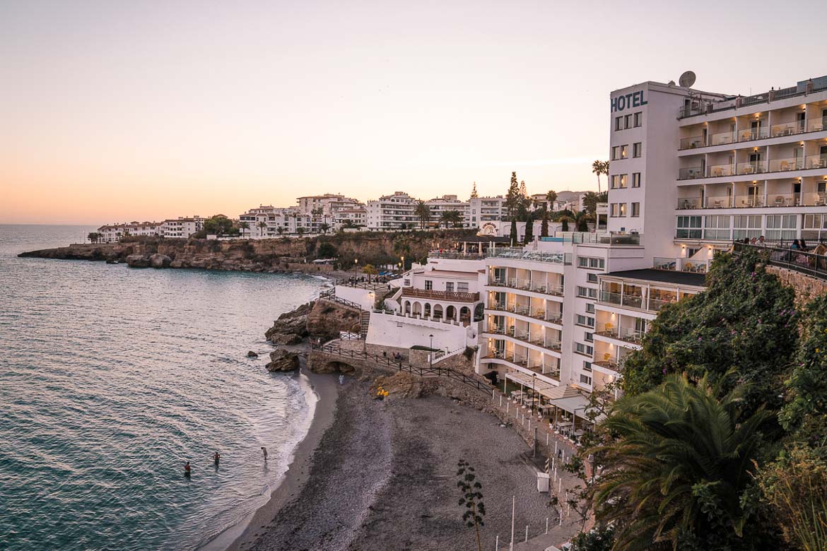 This image shows a big hotel on the beach. The town with its tall buildings is at the background. 