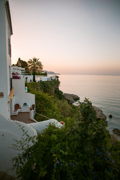 This image shows a quaint building built on a cliff with gorgeous sea views. 