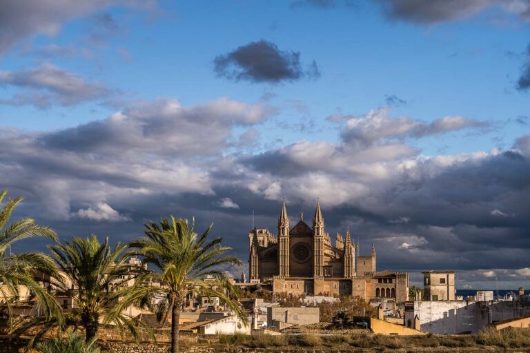 This image shows the Cathedral of Palma de Mallorca in winter, under a dramatic cloudy sky.
