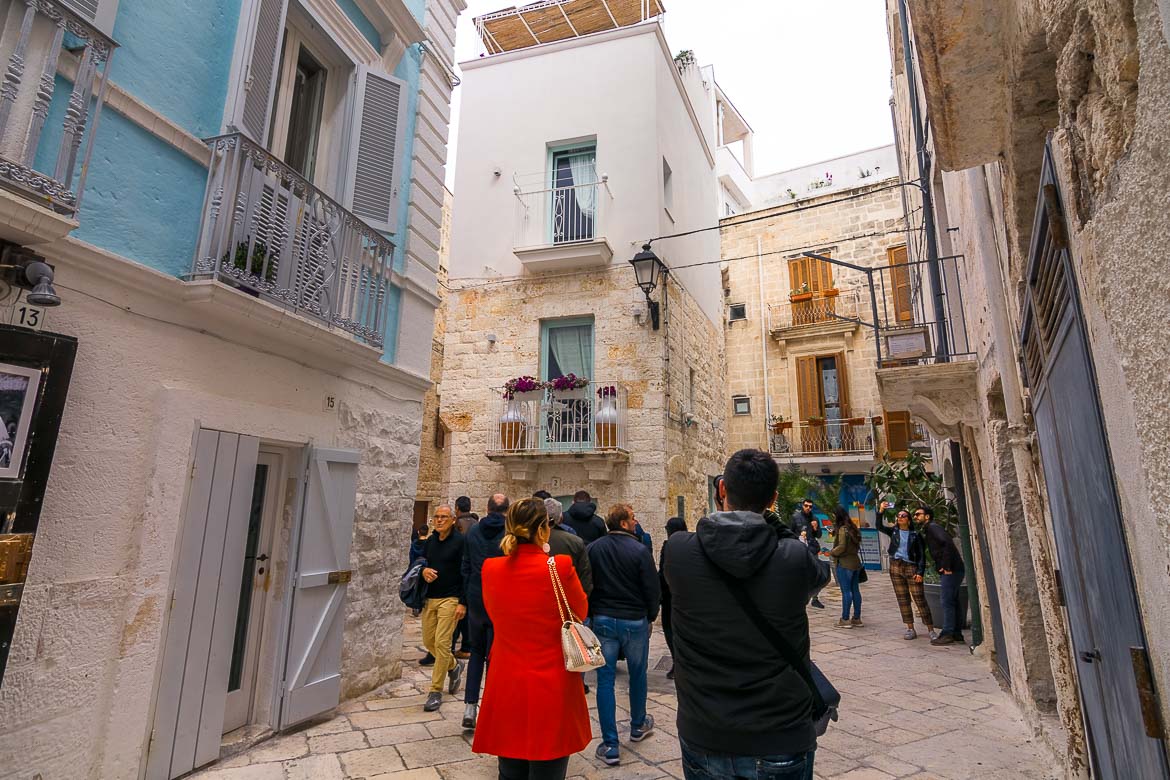 This photo shows crowds of people walking along a narrow street in the Old town.