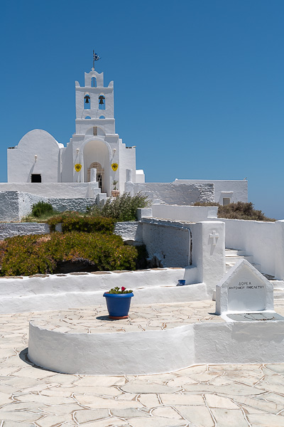 This is the interior courtyard of Chrissopigi Monastery. The white building shines bright under the afternoon sun.