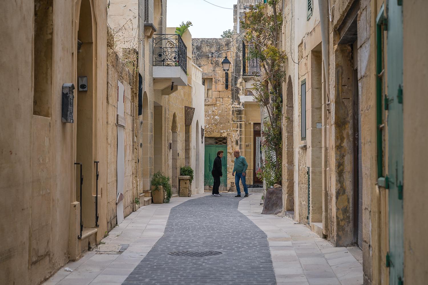 A man and a woman chatting in a quaint alley in Victoria.