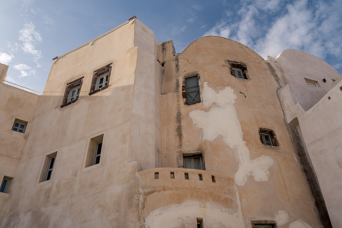 This is a close-up of the outer wall of Emporio Castle. There are small windows and doors.