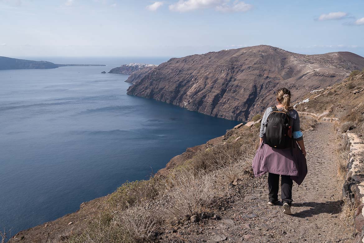 This image shows Maria walking along the hiking path that leads from Fira to Oia. The scenery is stunning as the caldera of Santorini is visible at every step. To the left, the Aegean Sea looks magnificent.