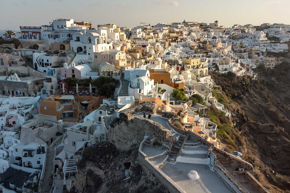 This is an aerial shot of Oia. Perched atop the volcanic cliff, Oia is one of the most gorgeous places to visit in Greece. If you're wondering why visit Santorini, Oia is definitely a valid reason to do so.