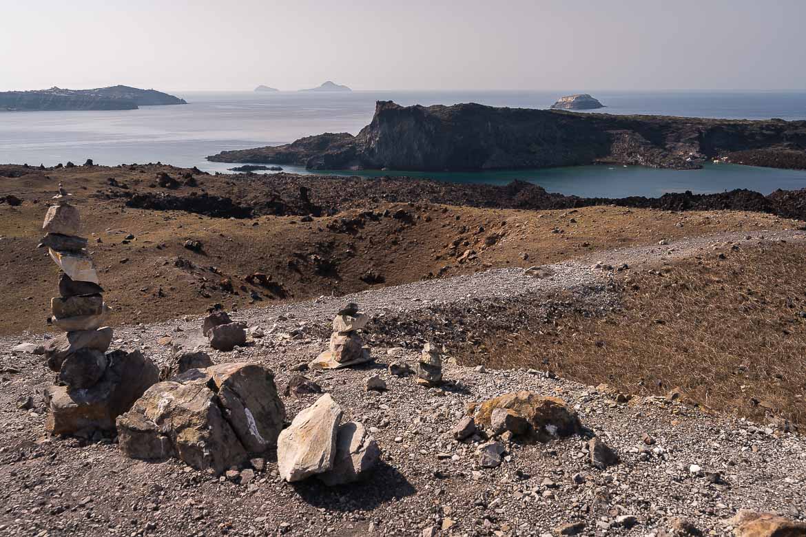 This image shows a path on Nea Kameni Island with Palea Kameni in the background.